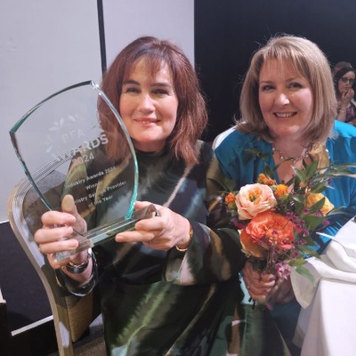Representatives from Direct2Florist proudly holding the Floristry Service Provider of the Year 2024 award alongside a celebratory bouquet at an industry awards ceremony.
